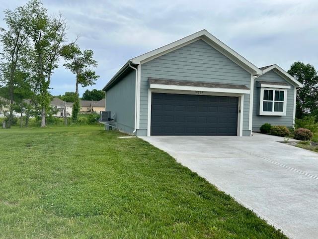10204 Siena Dr, Peculiar, MO 64078 - view of home's exterior featuring driveway, central AC, a lawn, and an attached garage