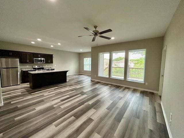 10204 Siena Dr, Peculiar, MO 64078 - unfurnished living room featuring baseboards, recessed lighting, wood finished floors, and a ceiling fan
