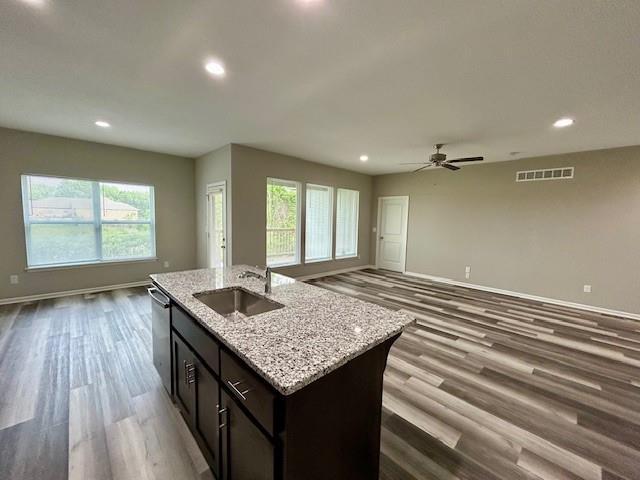 10204 Siena Dr, Peculiar, MO 64078 - kitchen featuring a sink, open floor plan, stainless steel dishwasher, dark wood finished floors, and baseboards
