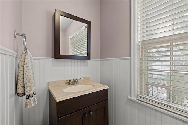 611 E 64th Ter, Kansas City, MO 64131 - bathroom featuring a wainscoted wall, vanity, and healthy amount of natural light