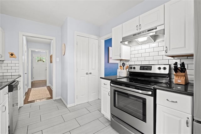 611 E 64th Ter, Kansas City, MO 64131 - kitchen with stainless steel appliances, under cabinet range hood, dark countertops, tasteful backsplash, and white cabinets