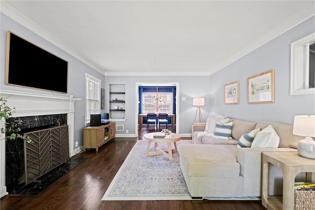 611 E 64th Ter, Kansas City, MO 64131 - living room featuring wood finished floors, ornamental molding, built in shelves, and a high end fireplace