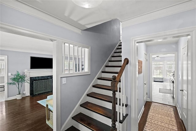 611 E 64th Ter, Kansas City, MO 64131 - staircase featuring wood finished floors, a fireplace, and ornamental molding