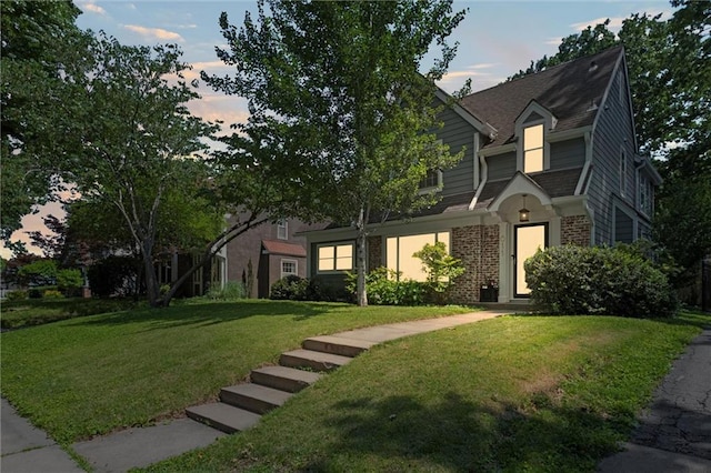 611 E 64th Ter, Kansas City, MO 64131 - view of front of house with a front yard, brick siding, and roof with shingles
