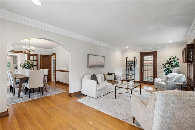 6661 Locust St, Kansas City, MO 64131 - living room featuring arched walkways, light wood-style flooring, a chandelier, baseboards, and recessed lighting
