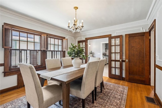6661 Locust St, Kansas City, MO 64131 - dining room featuring a chandelier, light wood-type flooring, baseboards, and ornamental molding
