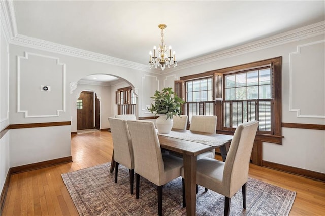6661 Locust St, Kansas City, MO 64131 - dining room featuring a chandelier, baseboards, arched walkways, light wood finished floors, and ornamental molding