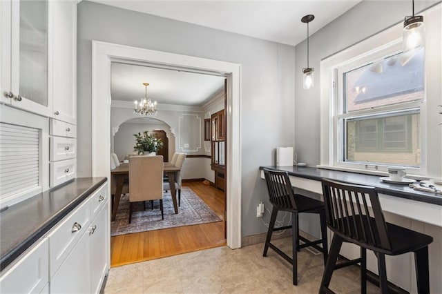 6661 Locust St, Kansas City, MO 64131 - dining space featuring a chandelier, arched walkways, and baseboards