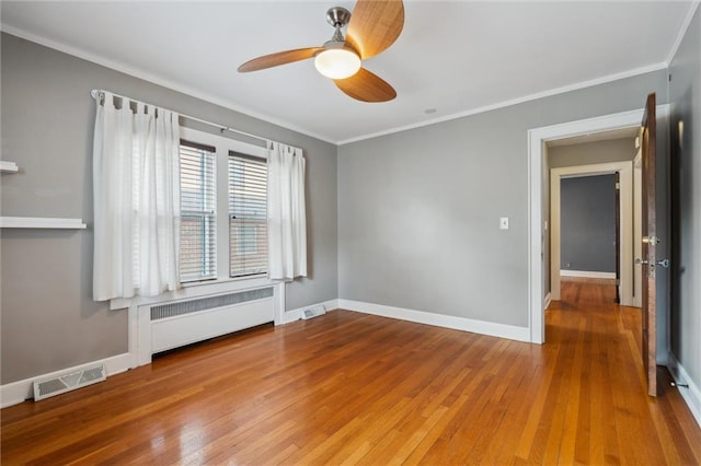 6661 Locust St, Kansas City, MO 64131 - empty room featuring radiator heating unit, hardwood / wood-style flooring, ornamental molding, ceiling fan, and baseboards