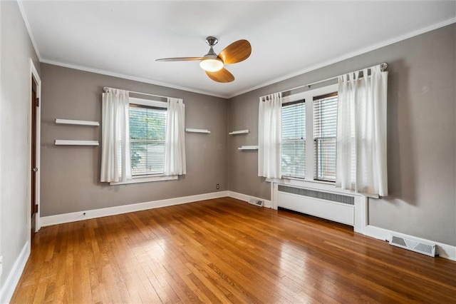 6661 Locust St, Kansas City, MO 64131 - spare room featuring radiator, hardwood / wood-style flooring, crown molding, a ceiling fan, and baseboards