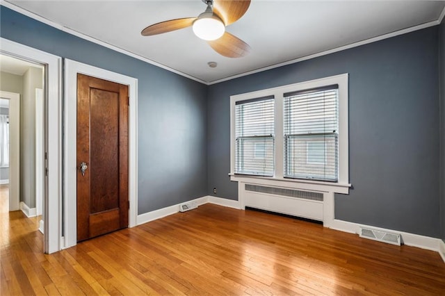 6661 Locust St, Kansas City, MO 64131 - empty room with radiator, light wood finished floors, a ceiling fan, baseboards, and ornamental molding