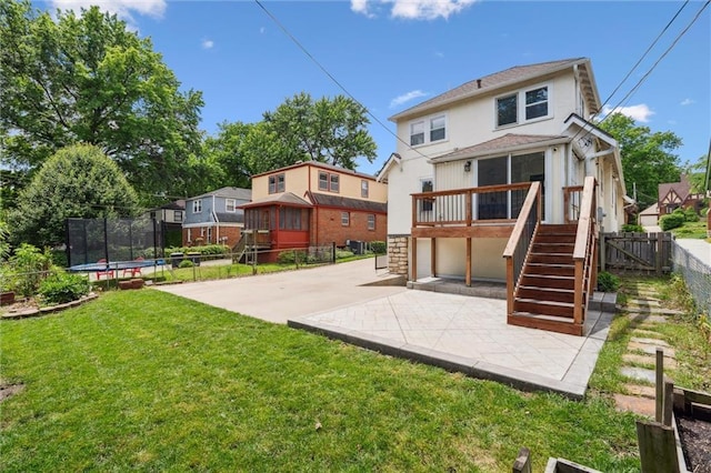 6661 Locust St, Kansas City, MO 64131 - rear view of house featuring stairs, a patio, stucco siding, a trampoline, and a deck