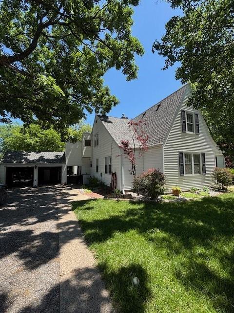 217 5th St, Burlington, KS 66839 - view of property exterior featuring a lawn and roof with shingles