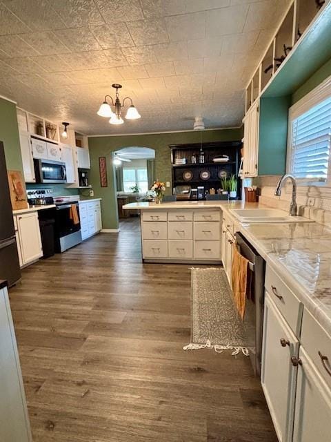 217 5th St, Burlington, KS 66839 - kitchen with appliances with stainless steel finishes, a sink, a chandelier, a peninsula, and white cabinets