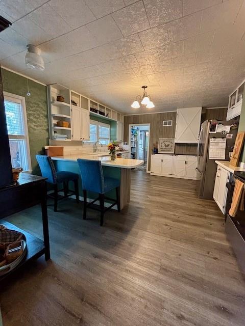 217 5th St, Burlington, KS 66839 - kitchen featuring a peninsula, plenty of natural light, open shelves, and dark wood-type flooring