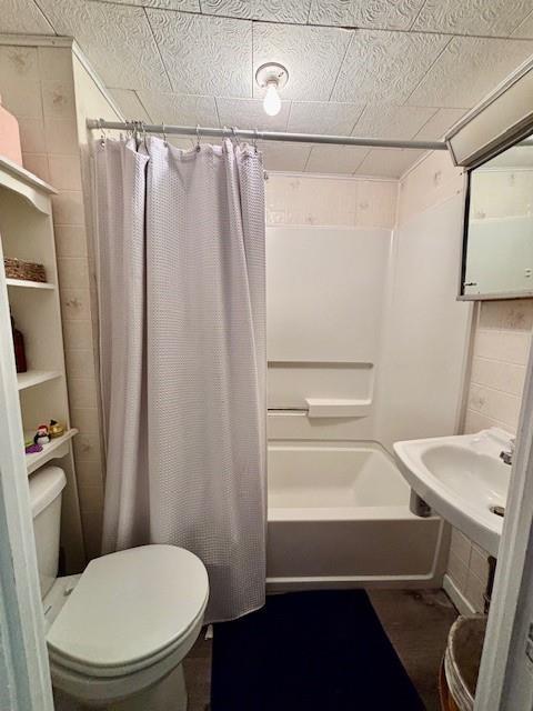 217 5th St, Burlington, KS 66839 - bathroom with toilet, shower / bath combination with curtain, and a sink