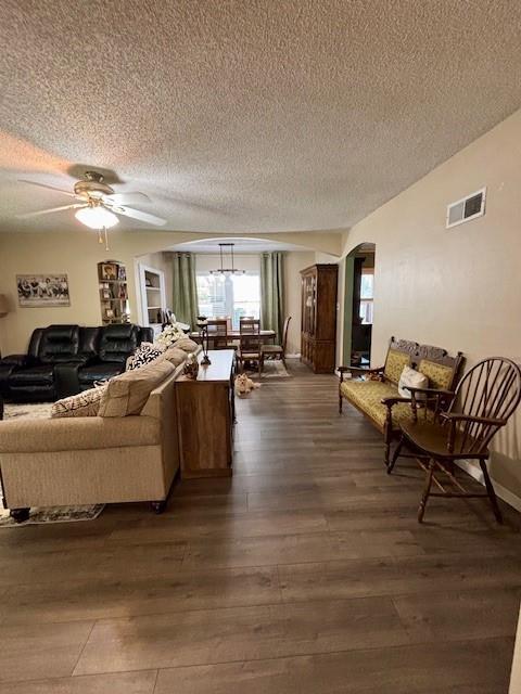 217 5th St, Burlington, KS 66839 - living area with a textured ceiling, dark wood-style floors, arched walkways, and a ceiling fan
