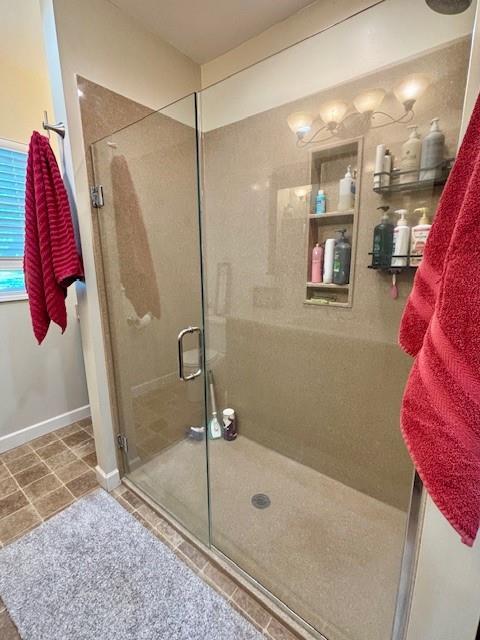 217 5th St, Burlington, KS 66839 - bathroom with a stall shower, tile patterned floors, and baseboards
