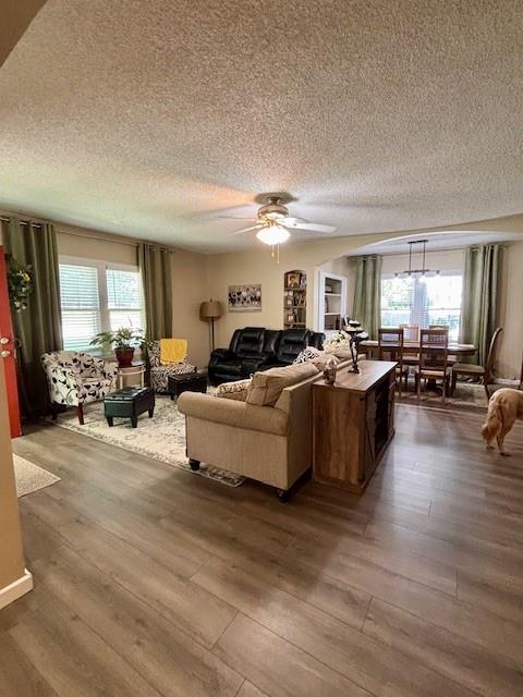 217 5th St, Burlington, KS 66839 - living area featuring a textured ceiling, dark wood-style flooring, healthy amount of natural light, and a ceiling fan