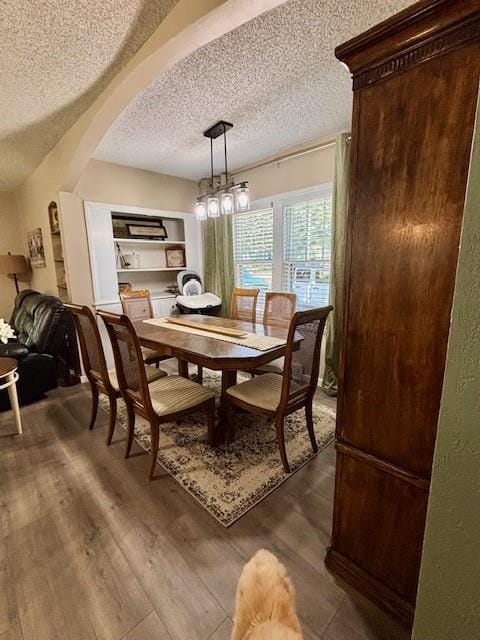 217 5th St, Burlington, KS 66839 - dining space featuring a textured ceiling, dark wood-style floors, and arched walkways