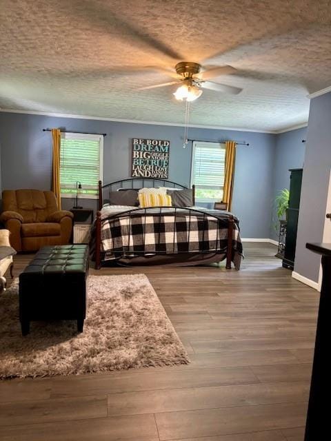 217 5th St, Burlington, KS 66839 - bedroom featuring a textured ceiling, crown molding, wood finished floors, baseboards, and a ceiling fan