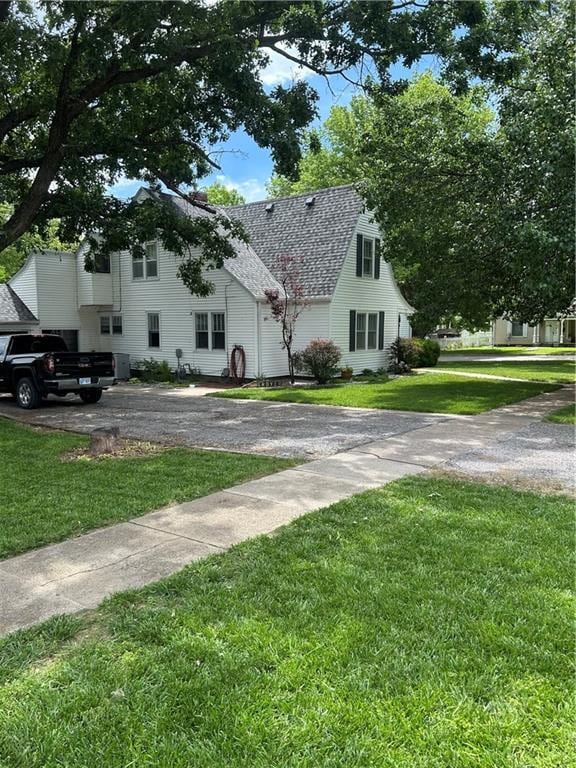 217 S 5th St, Burlington, KS 66839 - view of home's exterior with a shingled roof and a yard