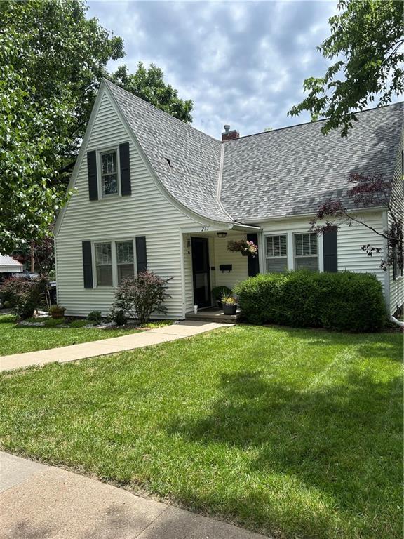 217 S 5th St, Burlington, KS 66839 - view of front facade with roof with shingles, a front lawn, and a chimney