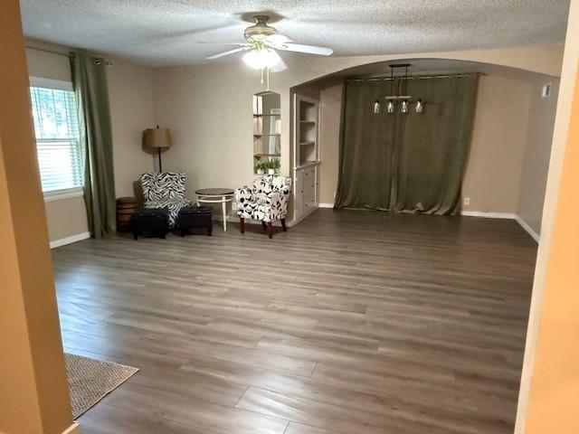 217 S 5th St, Burlington, KS 66839 - living room featuring a textured ceiling, ceiling fan, arched walkways, and wood finished floors