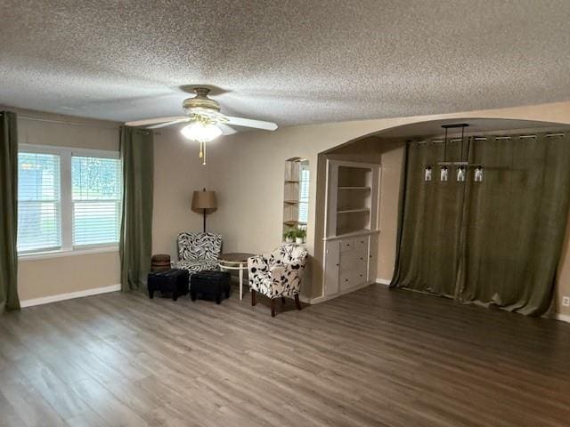 217 S 5th St, Burlington, KS 66839 - living area with a textured ceiling, wood finished floors, a ceiling fan, and arched walkways