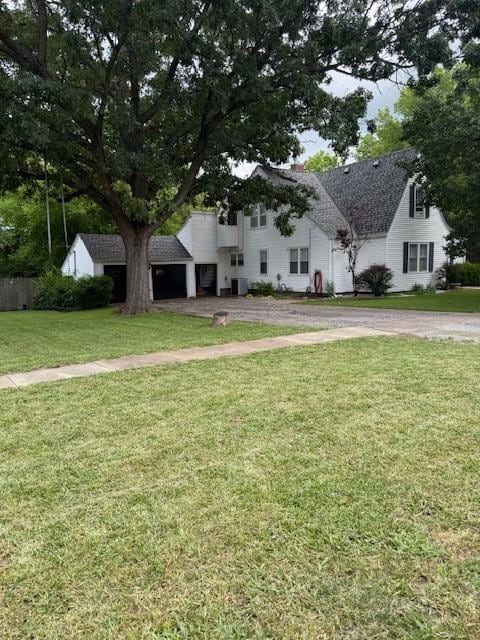 217 S 5th St, Burlington, KS 66839 - view of front of home with a front lawn, a shingled roof, and a garage