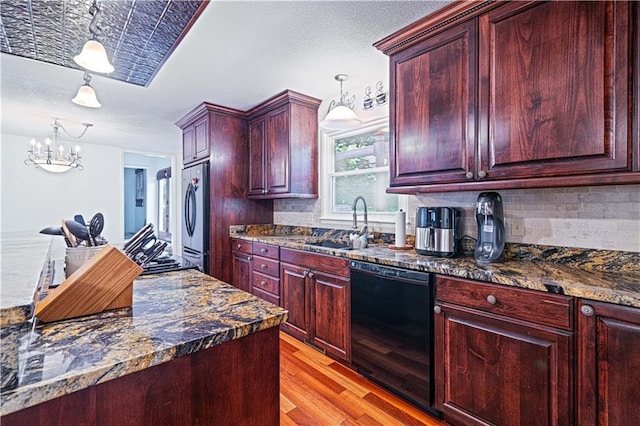 2002 N 29th St, Saint Joseph, MO 64506 - kitchen featuring black dishwasher, reddish brown cabinets, stainless steel refrigerator, light wood-style flooring, and a chandelier
