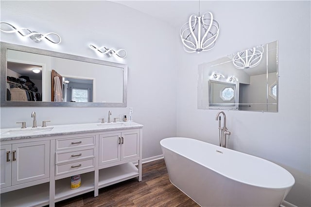 2002 N 29th St, Saint Joseph, MO 64506 - bathroom featuring a freestanding bath, double vanity, wood finished floors, a chandelier, and a walk in closet