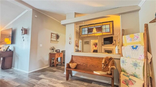 69 Porcupine Path, Linn Valley, KS 66040 - sitting room with wood finished floors, crown molding, baseboards, and lofted ceiling