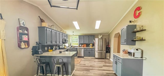 69 Porcupine Path, Linn Valley, KS 66040 - kitchen featuring appliances with stainless steel finishes, gray cabinetry, ornamental molding, a peninsula, and light wood-style flooring