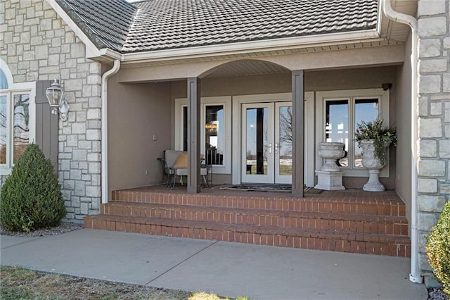 14971 Fairmount Rd, Basehor, KS 66007 - doorway to property featuring french doors, stone siding, a tiled roof, and stucco siding