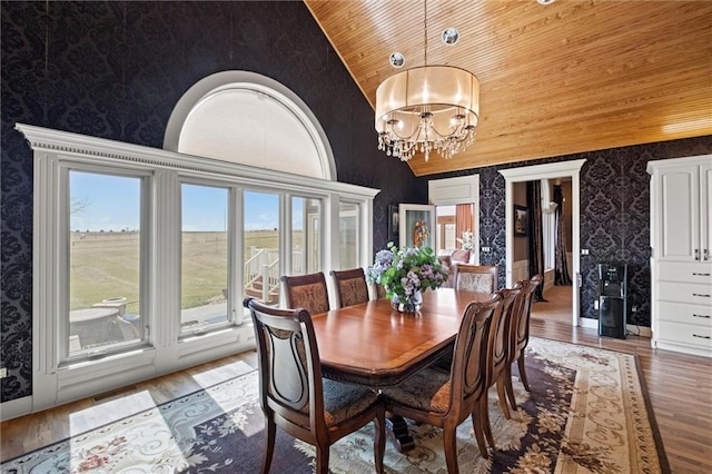 14971 Fairmount Rd, Basehor, KS 66007 - dining space with wallpapered walls, wooden ceiling, light wood-type flooring, a chandelier, and high vaulted ceiling