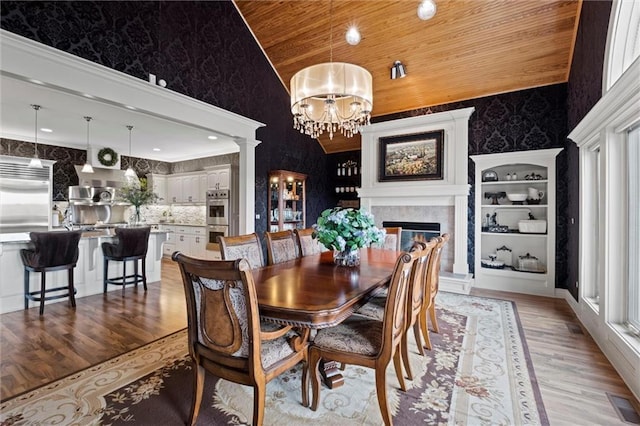 14971 Fairmount Rd, Basehor, KS 66007 - dining area featuring wooden ceiling, light wood-style flooring, a chandelier, plenty of natural light, and a premium fireplace