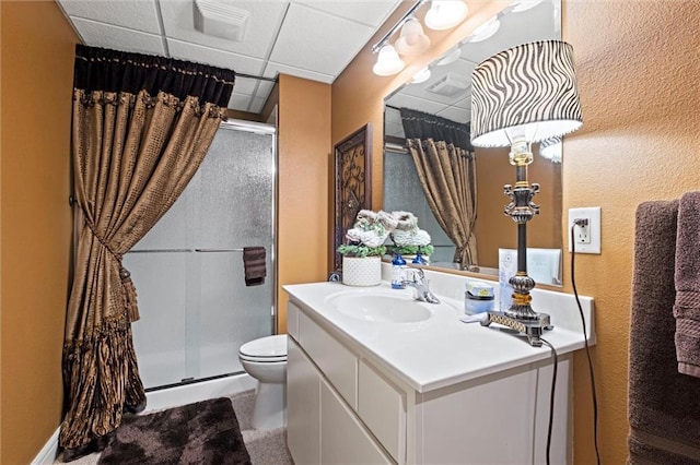 14971 Fairmount Rd, Basehor, KS 66007 - bathroom featuring a stall shower, toilet, vanity, and a paneled ceiling