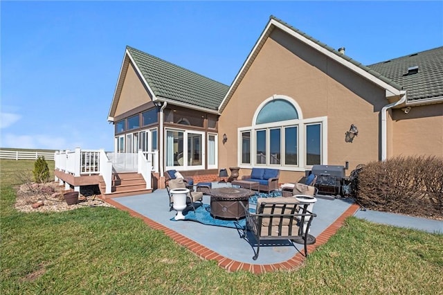 14971 Fairmount Rd, Basehor, KS 66007 - rear view of house with a patio area, a sunroom, a lawn, and an outdoor living space with a fire pit