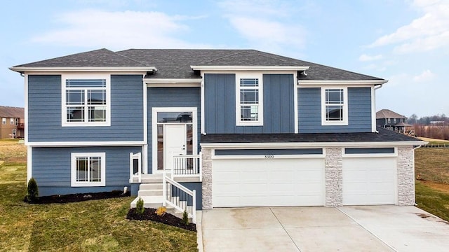 1348 N Holland Ct, Independence, MO 64056 - view of front of home with a garage, driveway, a front lawn, stone siding, and a shingled roof