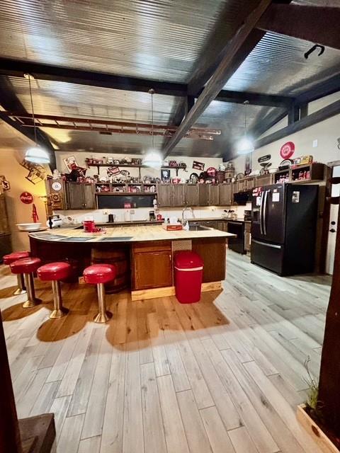 115 N 3rd St, Burlington, KS 66839 - bar area with black fridge, light wood-style flooring, a sink, and hanging light fixtures