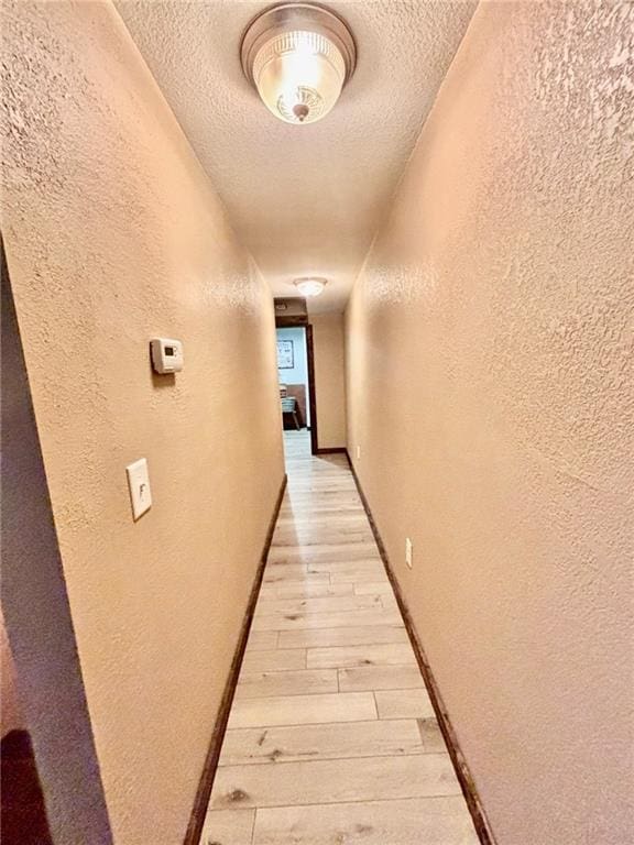 115 N 3rd St, Burlington, KS 66839 - hall featuring a textured wall, light wood-type flooring, and a textured ceiling