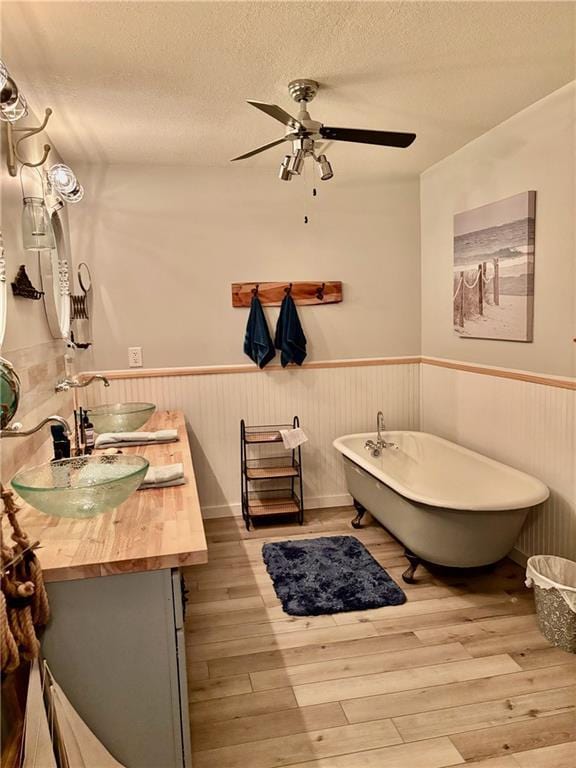 115 N 3rd St, Burlington, KS 66839 - full bathroom with vanity, wainscoting, wood finished floors, a freestanding bath, and ceiling fan