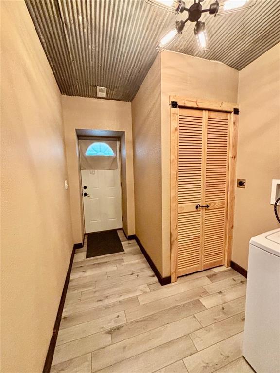 115 N 3rd St, Burlington, KS 66839 - entryway featuring light wood finished floors, ceiling fan, baseboards, and washer / dryer