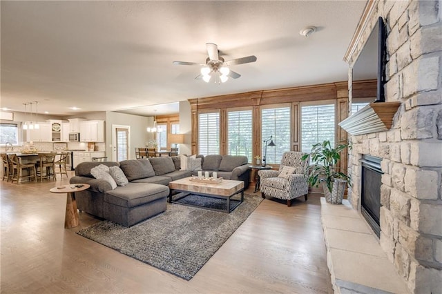 5204 W 166th St, Overland Park, KS 66085 - living area featuring a fireplace, a ceiling fan, wood finished floors, and plenty of natural light