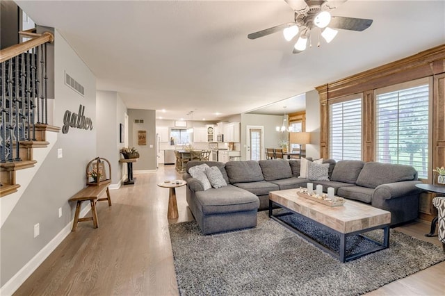 5204 W 166th St, Overland Park, KS 66085 - living room featuring light wood-style floors, ceiling fan, baseboards, and plenty of natural light