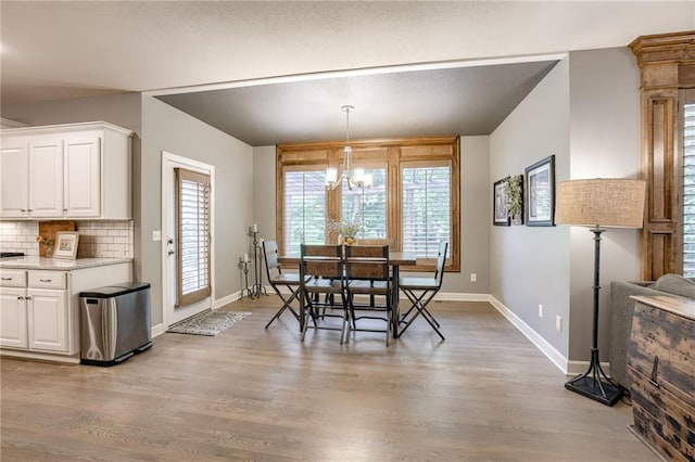 5204 W 166th St, Overland Park, KS 66085 - dining area with baseboards, light wood-style flooring, and a chandelier