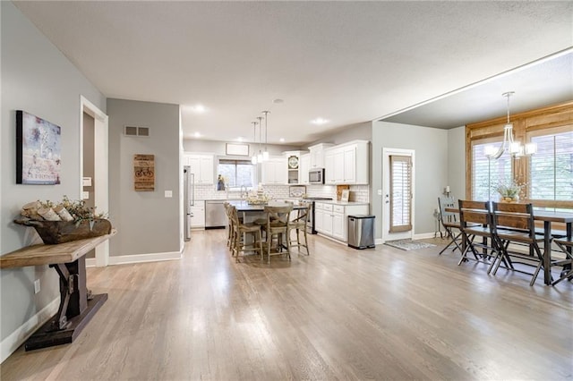 5204 W 166th St, Overland Park, KS 66085 - dining area with light wood-type flooring, plenty of natural light, a chandelier, baseboards, and recessed lighting