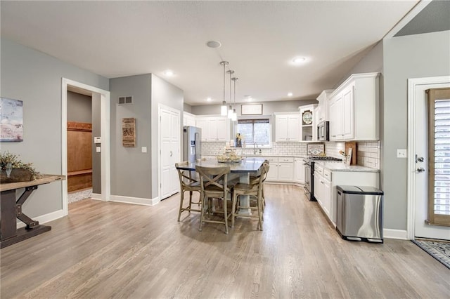 5204 W 166th St, Overland Park, KS 66085 - kitchen featuring appliances with stainless steel finishes, light wood-type flooring, white cabinets, tasteful backsplash, and recessed lighting
