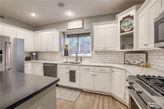 5204 W 166th St, Overland Park, KS 66085 - kitchen featuring stainless steel appliances, a sink, white cabinets, light wood finished floors, and recessed lighting